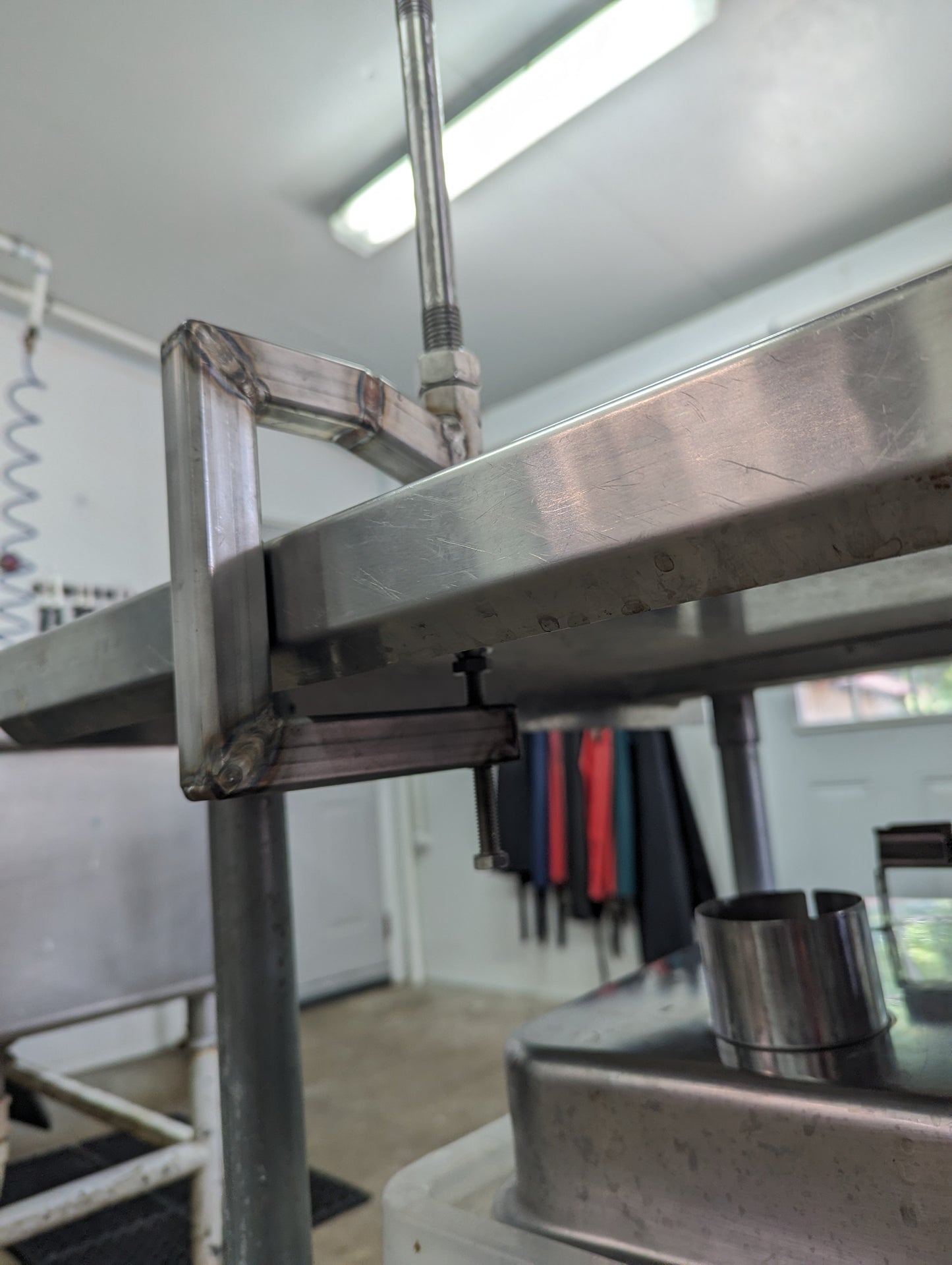 Cluck Clamp - Poultry Cut-up Cone and Clamp securely attached to a table, crafted from high-quality 304 stainless steel.